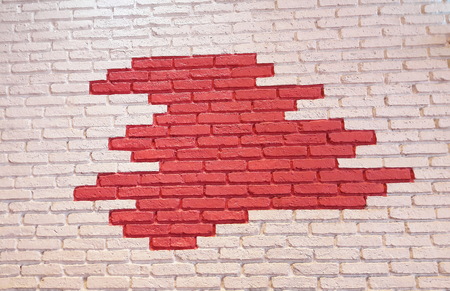 Bricked wall was painted by white in contour and red color is in center of it.の写真素材