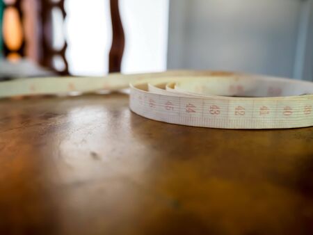 Tapeline is needlework and is placed on wooden table.の写真素材