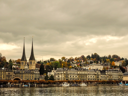 21 Oct 2016, This photo was took from opposite side of Hofkirche where is landmark of Lucerne, Switzerland and it is famous place of tourists for sightseeing. Hofkirche places in between peopleâs houses and hotel while many boats anchored at Reuss riverのeditorial素材