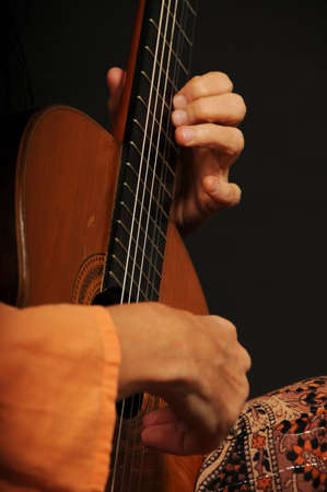 Close up of an acoustic guitar being played by a woman