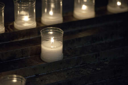 Close up of votive candles, twilight, in a dark Christian church. Selective focusの写真素材
