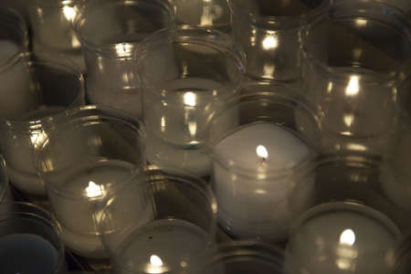 Close up of votive candles, twilight, in a dark Christian church. Selective focusの写真素材