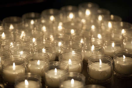 Close up of votive candles, twilight, in a dark Christian church. Selective focusの写真素材