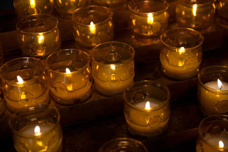 Close up of votive candles, twilight, in a dark Christian church. Selective focusの写真素材