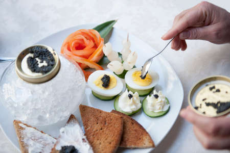 Luxury appetizers with caviar, eggs, onions and slices of bread.の写真素材