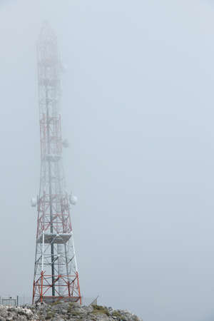 Ground view of telecommunication towers in the clouds on a mountain peak on the Crete island.の写真素材