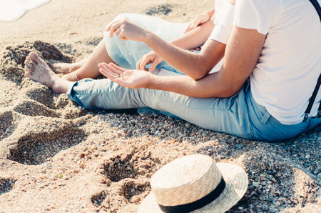 Close up of couple sitting sitting on the sand on the beach. Summer love concept. Holiday relaxing,...