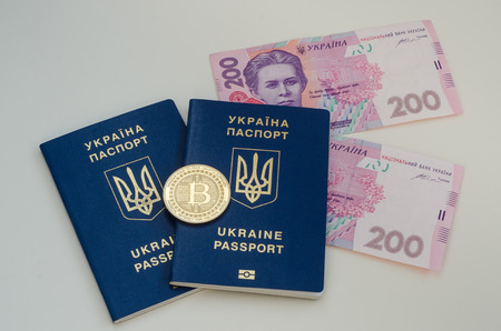 Ukrainian foreign passports and money and bitcoin coin. Ukraine and cryptocurrency concept. Isolated...