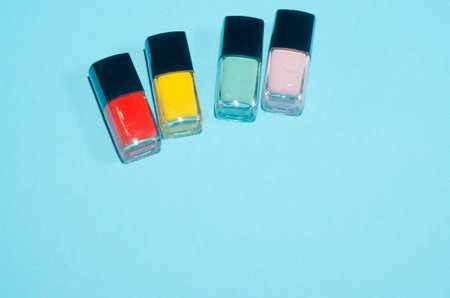 Set of red, pink, green and yellow.nail polish. Make up beauty products on blue background.  Decorative cosmetics. Top view, flatlay. Copyplace. Concept of color.の写真素材