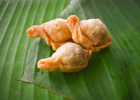 thai dessert called pan-klib or fried flour stuffed with fish on banana leafの写真素材