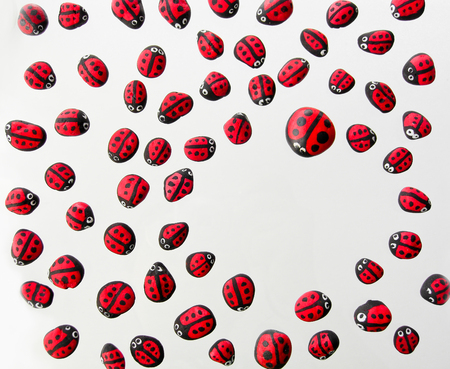 ladybirds painted on cobblestone in isolated white backgroundの写真素材