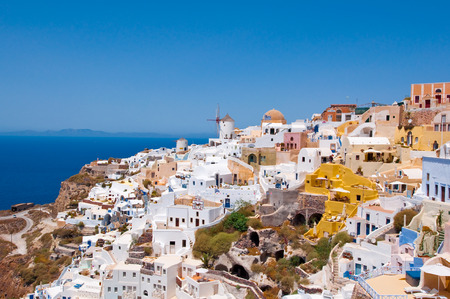 Colorful Oia village on the edge of the caldera cliffs with windmills in the distance on the island of Thira (Santorini), Greece.のeditorial素材