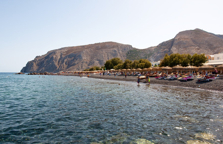 SANTORINI,FIRA-JULY 28: Tourists sunbathe on the Kamari Beach on July 28,2014 on the island of Santorini(Thira), Greece. Kamari beach is located on the eastern coast of Santorini Island.のeditorial素材