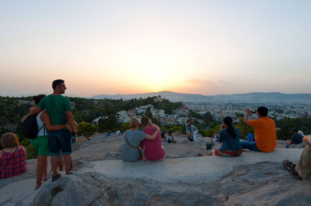 ATHENS-AUGUST 22: Tourists enjoy sunset on Areopagus hill on August 22, 2014 in Athens, Greece. Areopagus hill is located just bellow the entrance of the Acropolis.のeditorial素材