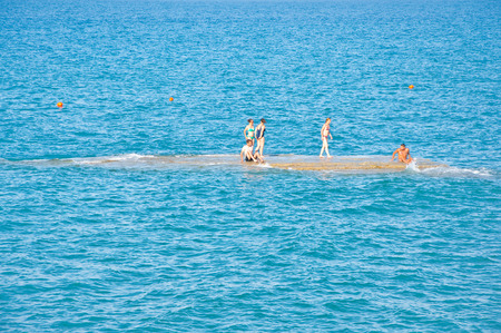 CORFU-AUGUST 26: People sunbath on an isle next to the sandy Sidary beach on August 26,2014 on the Corfu island, Greece.のeditorial素材