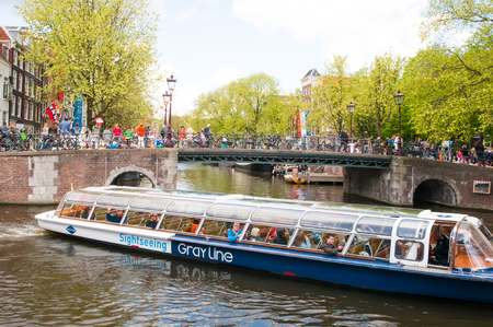 AMSTERDAMNETHERLANDSAPRIL 27: Tourist boat on the channel of Amsterdam on April 272015. The Netherlands.のeditorial素材