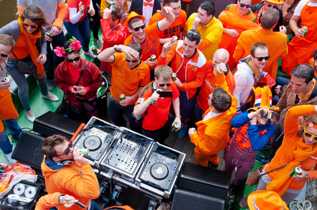 AMSTERDAM NETHERLANDS APRIL 27: People dressed in orange celebrate King39s Day on a boat on April 272 015 in Amsterdam. King39s Day is the largest openair festivity in Amsterdam.のeditorial素材