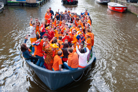 AMSTERDAM NETHERLANDS APRIL 27: Crowd of people dressed in orange celebrate King39s Day in a boat on April 272 015 in Amsterdam. King39s Day is the largest openair festivity in Amsterdam.のeditorial素材