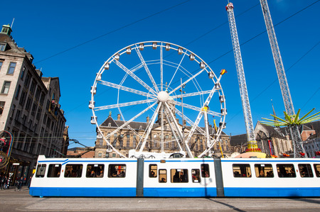 AMSTERDAM,NETHERLANDS-APRIL 27: Ferris wheel with Royal Palace in the background on Dam Square on the eve of King's Day on April 27,2015.  King's Day is the largest open-air festivity in Amsterdam.のeditorial素材