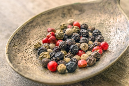 Closeup mixed peppercorns in silver rustic spoon.の写真素材