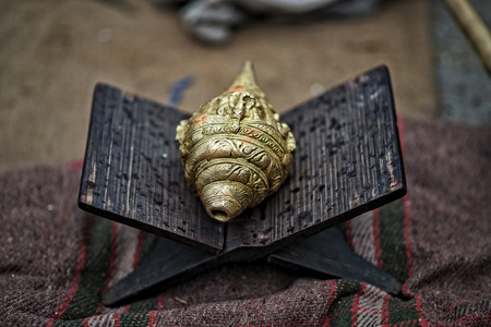 Brass conch shell (Shankha) - religious importance in Hinduism and Buddhism on the wooden folding...