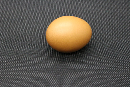 Chicken egg isolated on a black background. Close-up. Selective focus.の写真素材