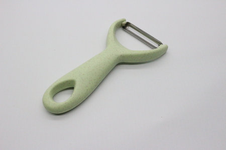 Green fruit and vegetable skin peeler, white background.の写真素材
