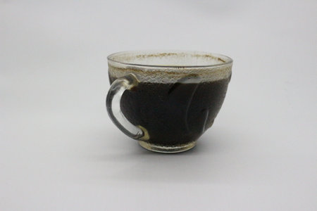 Black coffee served in a clear glass, with a white background.の写真素材