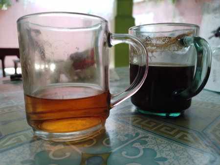 A cup of coffee and a glass of tea are on the table. hanging out cultureの写真素材