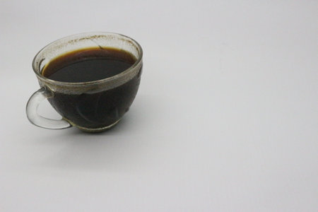 Black coffee served in a clear glass, with a white background.の写真素材