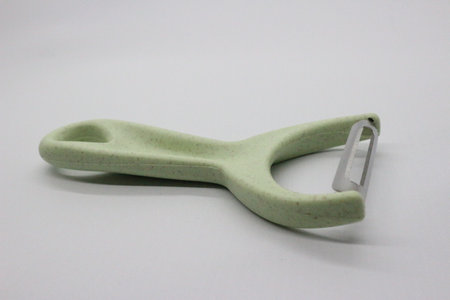 Green fruit and vegetable skin peeler, white background.の写真素材