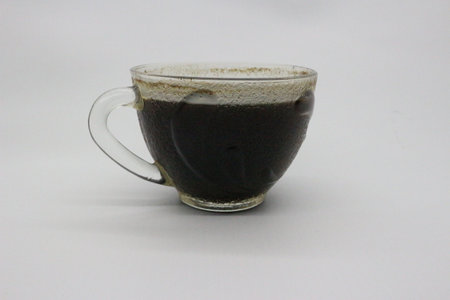 Black coffee served in a clear glass, with a white background.の写真素材