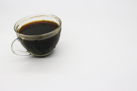 Black coffee served in a clear glass, with a white background.の写真素材