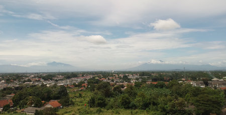 Landscapes. The scenery is very beautiful, there is a village and several mountains behind it and accompanied by a bright blue sky.の写真素材