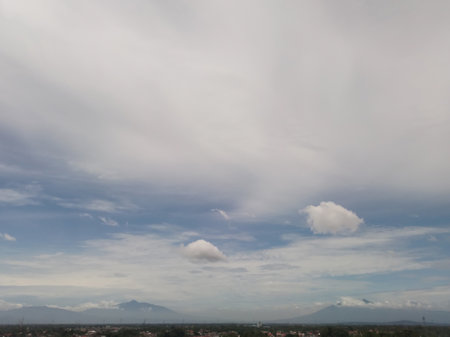 Landscapes. The scenery is very beautiful, there is a village and several mountains behind it and accompanied by a bright blue sky.の写真素材