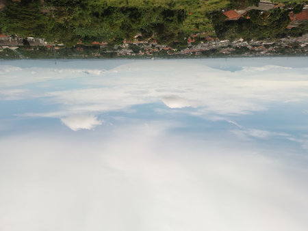 Landscapes. The scenery is very beautiful, there is a village and several mountains behind it and accompanied by a bright blue sky.の写真素材