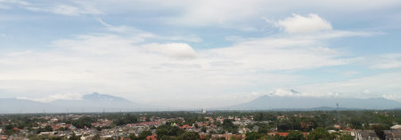 Landscapes. The scenery is very beautiful, there is a village and several mountains behind it and accompanied by a bright blue sky.の写真素材