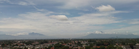 Landscapes. The scenery is very beautiful, there is a village and several mountains behind it and accompanied by a bright blue sky.の写真素材