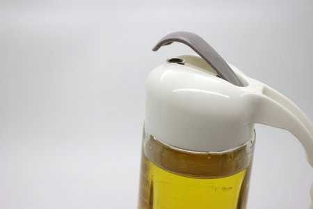 A large drinking bottle filled with yellow liquor with a white lid on the floorの写真素材
