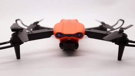 Orange drone with camera on white floor