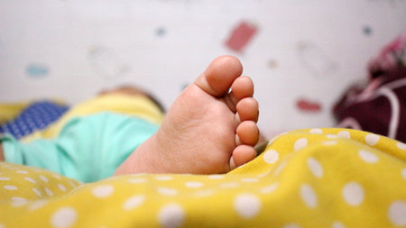 Close up of little baby's feet on the mattressの写真素材
