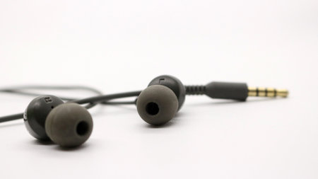 Close up of black wired earphones on white backgroundの写真素材