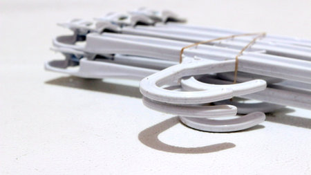 A pile of white clothes hangers on a white backgroundの写真素材