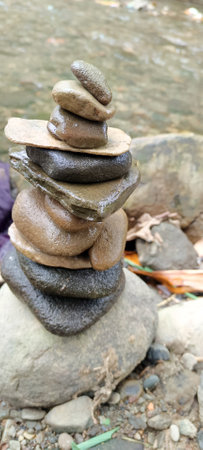 Close up of stacks of rocks on the river bank in a forest