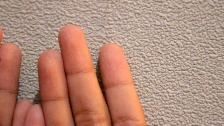 Photo of two small children's hands looking up. With a silver background.