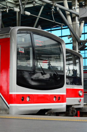View of a train station, one is stopping. You can see two train tracks, and this is truly a...