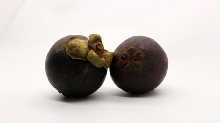 Two mangosteens isolated on a white background
