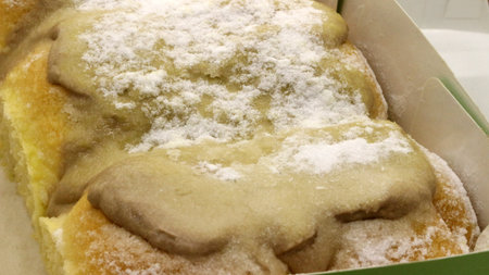 Bread in a box topped with vanilla jam and powdered sugar.