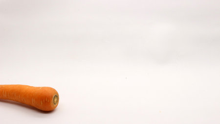 A carrot on a white background, a carrot on an orange color looks very fresh.の写真素材