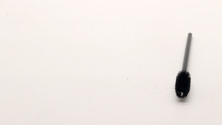 Black eyelash comb on a white background.